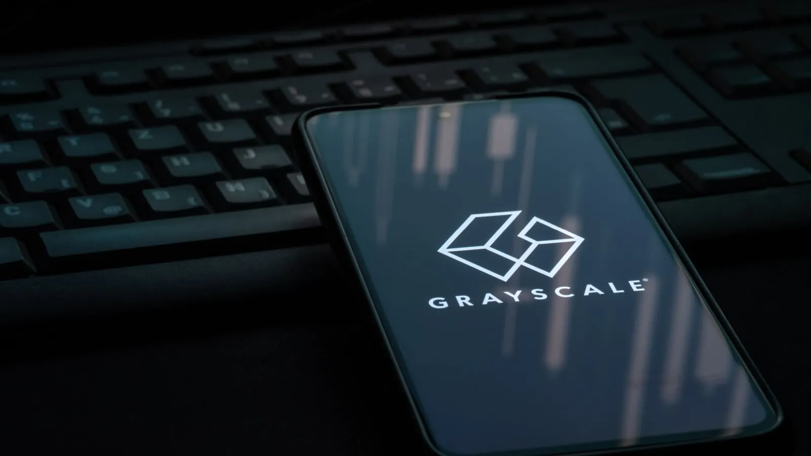 Grayscale logo on smart phone in dark room. Source: Shutterstock